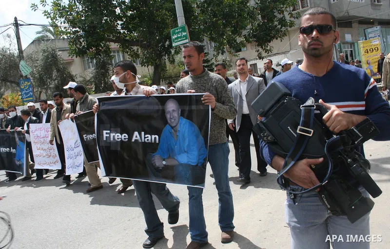 Palestinian journalists hold a poster during a protest calling for the release of kidnapped BBC correspondent Alan Johnston in Gaza. Palestinian journalists began a three-day strike on Monday to press the government to e...