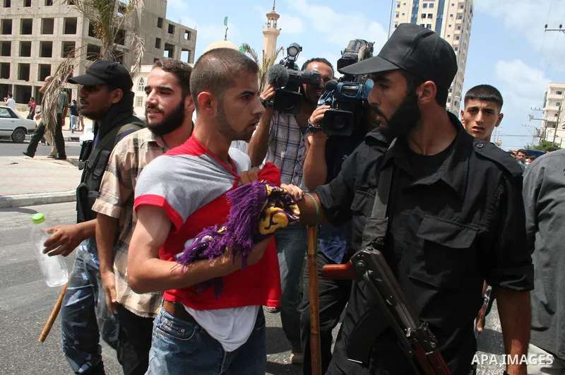 Members of the Hamas Executive Forces arrest a Palestinian Fatah party supporter as he and others try to attend Friday noon prayers in an outdoors setting in Gaza City. Hamas police wounded 11 Palestinians as they broke...