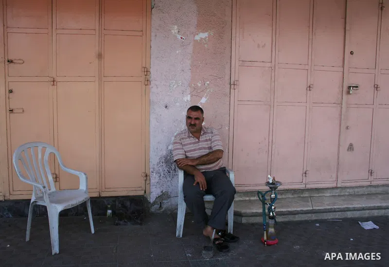 A Palestinian shopkeeper sits outside closed shops during a general strike called by supporters of the Fatah Movement in the West Bank. Activists in the Fatah movement declared a general strike across the Gaza Strip and...