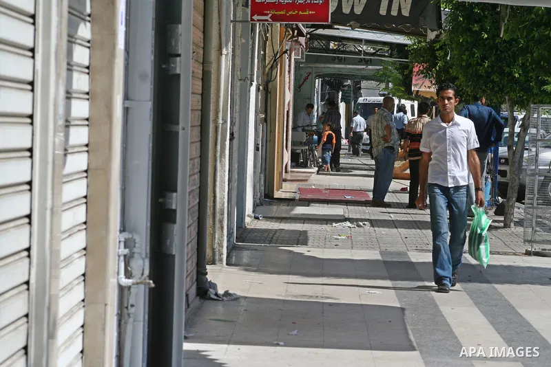Palestinians walk passed closed shops during a general strike called by supporters of the Fatah Movement in the West Bank. Activists in the Fatah movement declared a general strike across the Gaza Strip and parts of the...