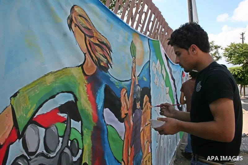 palestinian artist have no palestinian ID card paints a mural to reflects their tragic situation due to depriving them from The right of citizenship and Travel freely to visit their relatives outside the Palestinian Terr...