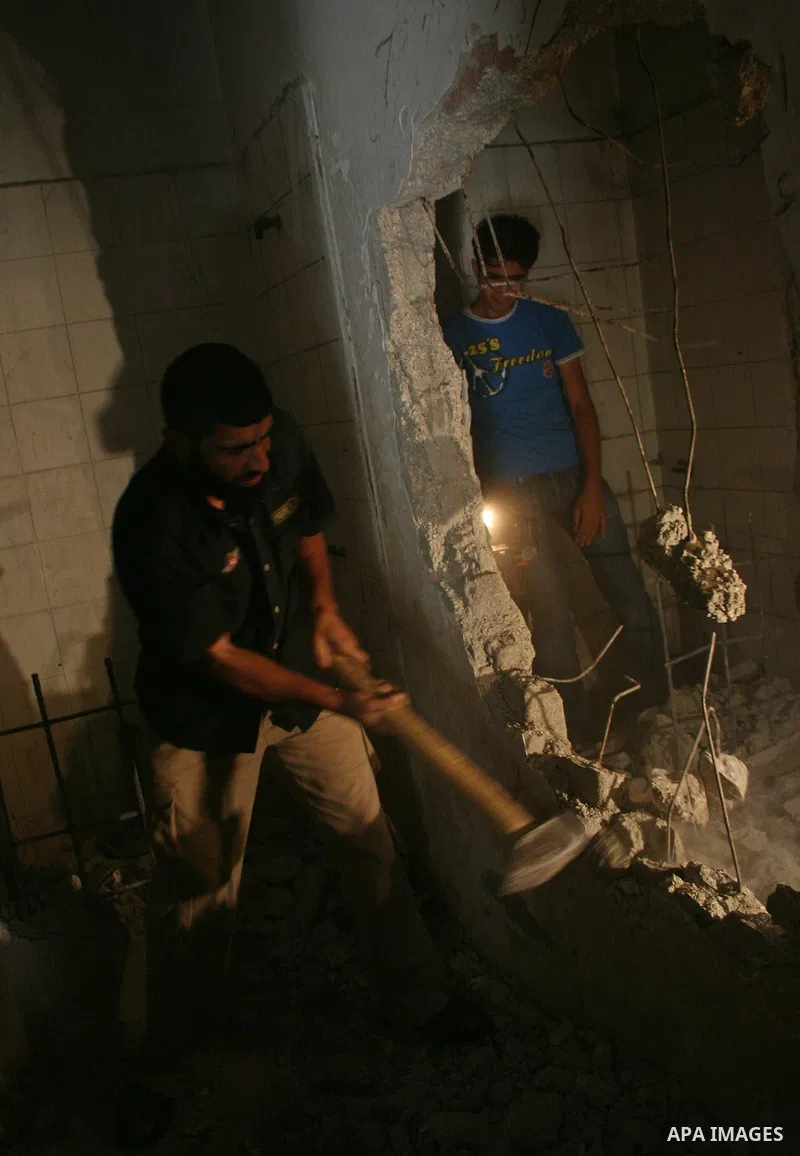 A member of Hamas's Executive Force destroys the wall of a cell at the old Gaza Central Prison in Gaza City. Hamas's self-styled police force said today it has found and defused a bomb placed near the Palestinian parliam...