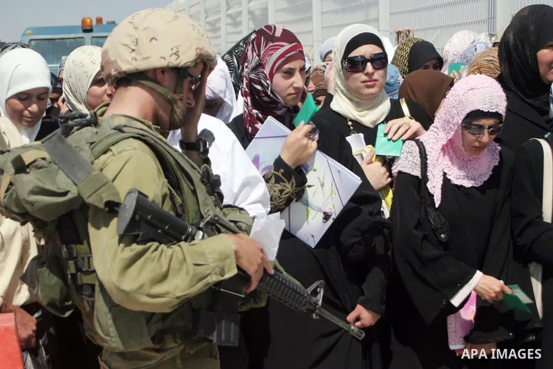 Israeli soldiers stand by Palestinians crossing the Hawara checkpoint near the West Bank city of Nablus. Prime Minister Ehud Olmert on Sunday hinted there would be no major breakthroughs in peacemaking ahead of a U.S. sp...