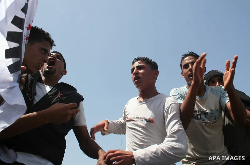 Palestinian workers shout and wave flags during a demonstration against the siege in Gaza city. Palestinians have chosen to demonstrate in the run up to Labour Day against the closure of checkpoints between the Gaza Stri...