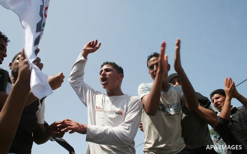 Palestinian workers shout and wave flags during a demonstration against the siege in Gaza city. Palestinians have chosen to demonstrate in the run up to Labour Day against the closure of checkpoints between the Gaza Stri...