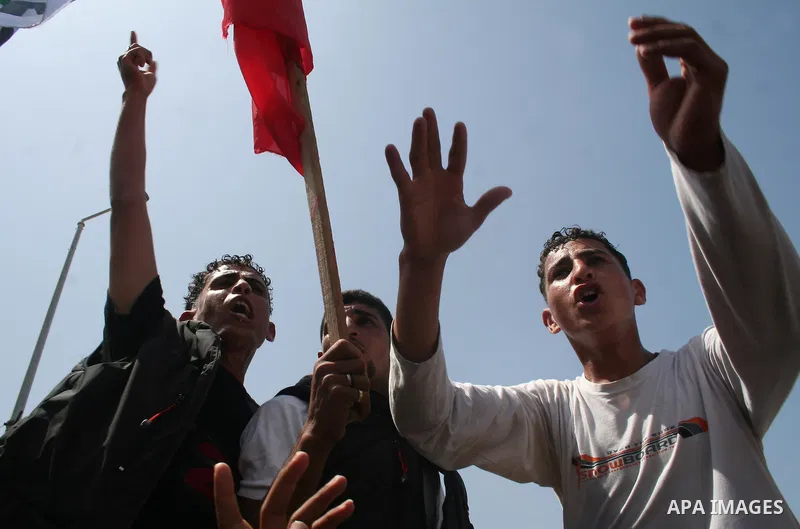 Palestinian workers shout and wave flags during a demonstration against the siege in Gaza city. Palestinians have chosen to demonstrate in the run up to Labour Day against the closure of checkpoints between the Gaza Stri...