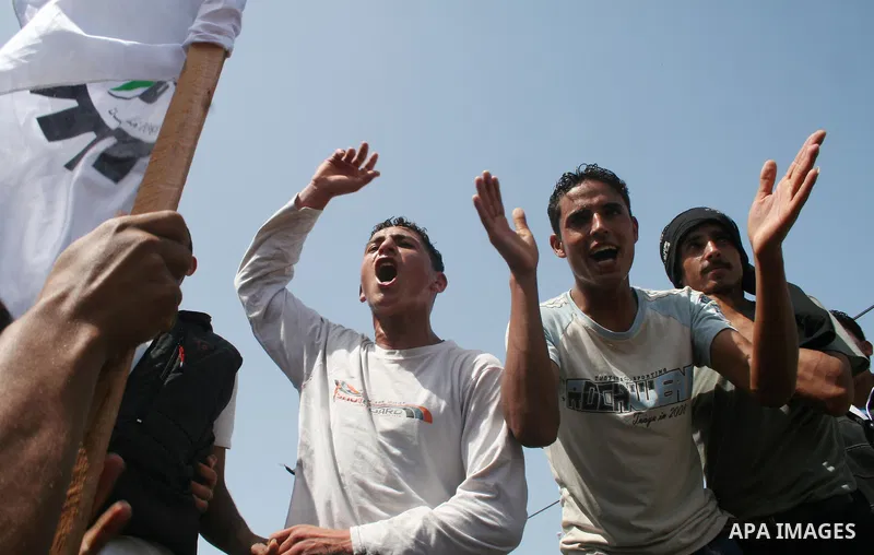 Palestinian workers shout and wave flags during a demonstration against the siege in Gaza city. Palestinians have chosen to demonstrate in the run up to Labour Day against the closure of checkpoints between the Gaza Stri...