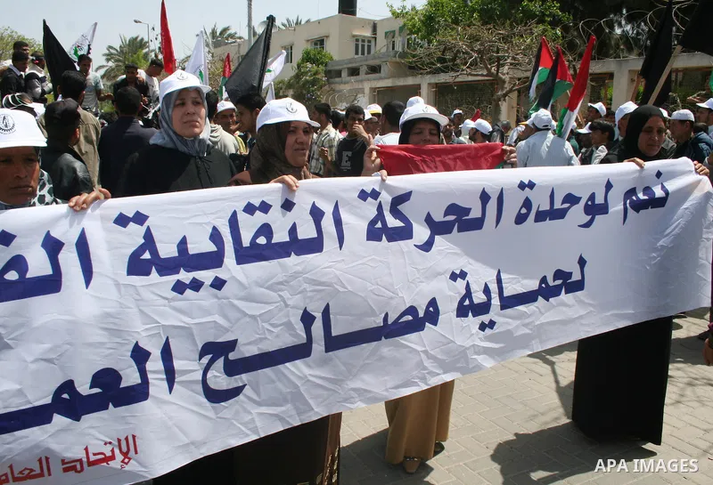 Palestinian workers shout and wave flags during a demonstration against the siege in Gaza city. Palestinians have chosen to demonstrate in the run up to Labour Day against the closure of checkpoints between the Gaza Stri...
