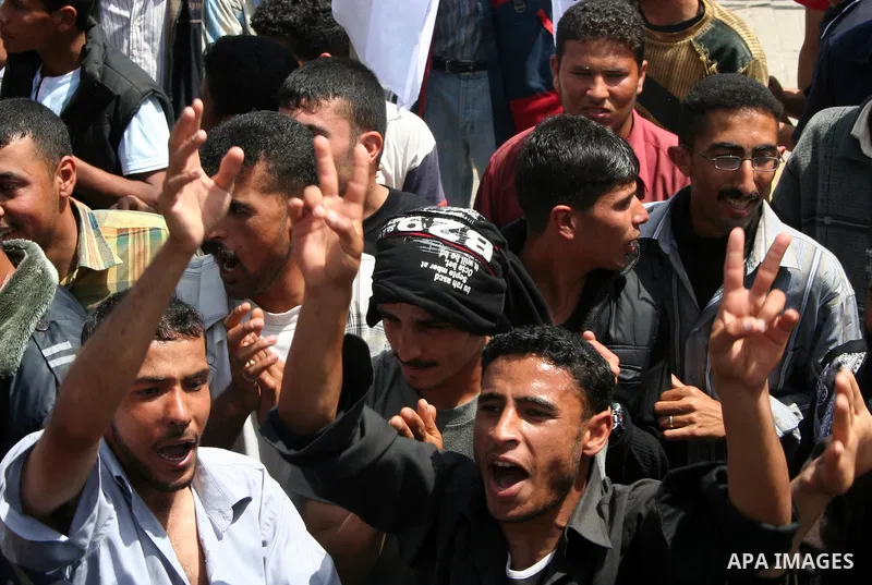 Palestinian workers shout and wave flags during a demonstration against the siege in Gaza city. Palestinians have chosen to demonstrate in the run up to Labour Day against the closure of checkpoints between the Gaza Stri...