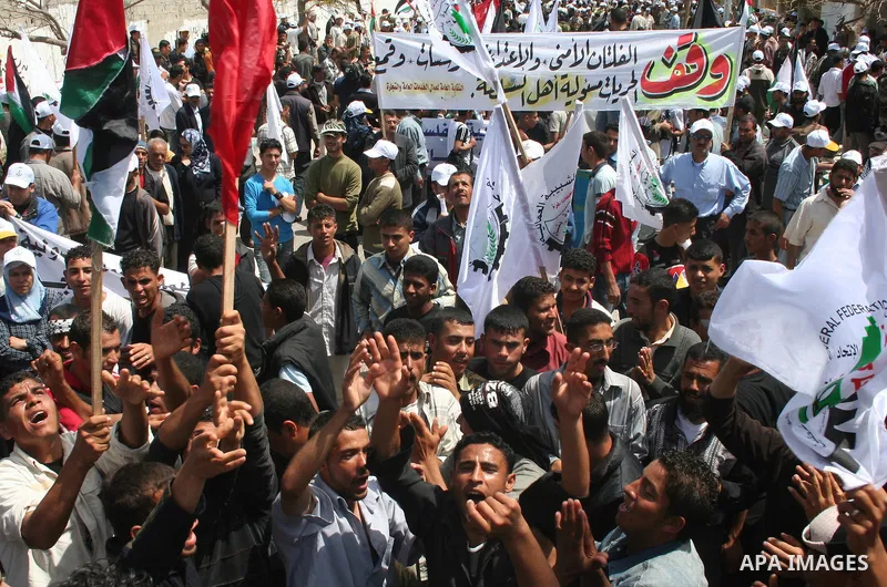 Palestinian workers shout and wave flags during a demonstration against the siege in Gaza city. Palestinians have chosen to demonstrate in the run up to Labour Day against the closure of checkpoints between the Gaza Stri...