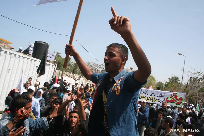 Palestinian workers shout and wave flags during a demonstration against the siege in Gaza city. Palestinians have chosen to demonstrate in the run up to Labour Day against the closure of checkpoints between the Gaza Stri...