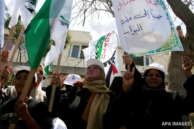 Palestinian workers shout and wave flags during a demonstration against the siege in Gaza city. Palestinians have chosen to demonstrate in the run up to Labour Day against the closure of checkpoints between the Gaza Stri...