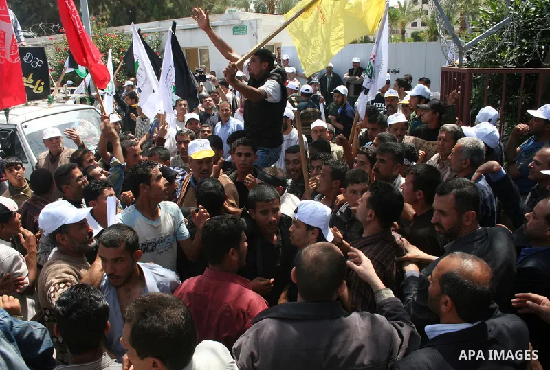 Palestinian workers shout and wave flags during a demonstration against the siege in Gaza city. Palestinians have chosen to demonstrate in the run up to Labour Day against the closure of checkpoints between the Gaza Stri...