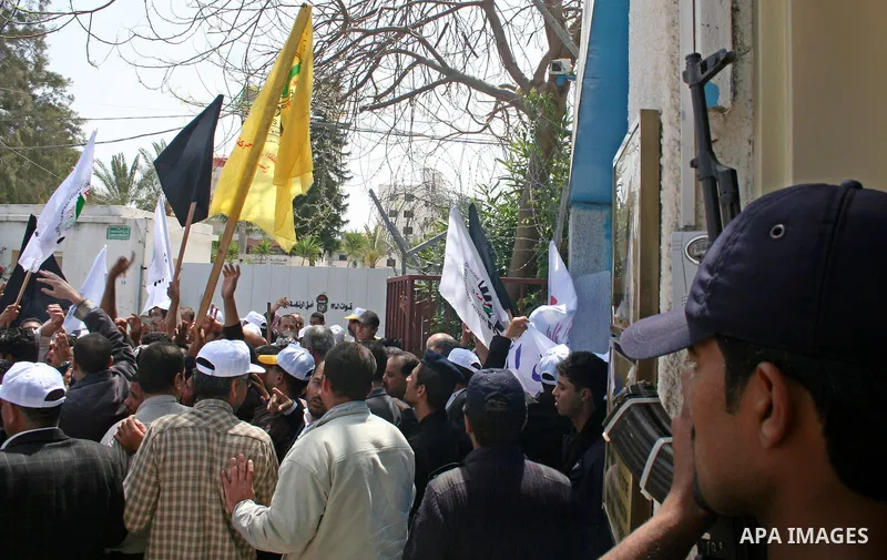 Palestinian workers shout and wave flags during a demonstration against the siege in Gaza city. Palestinians have chosen to demonstrate in the run up to Labour Day against the closure of checkpoints between the Gaza Stri...