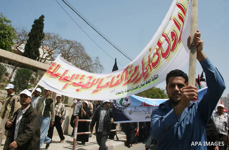 Palestinian workers shout and wave flags during a demonstration against the siege in Gaza city. Palestinians have chosen to demonstrate in the run up to Labour Day against the closure of checkpoints between the Gaza Stri...