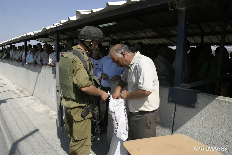 An Israeli soldier inspect a Palestinian man at the Hawara checkpoint near the West Bank city of Nablus. The Israeli military announced an open-ended closure of the West Bank and Gaza Strip Wednesday, ahead of the weeklo...