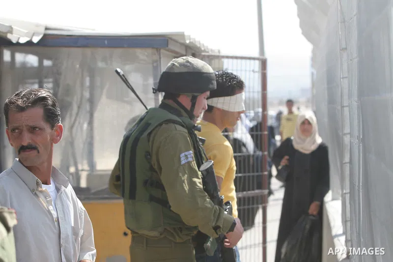 An Israeli soldier detains a Palestinian youth at the Hawara checkpoint near the West Bank city of Nablus. The Israeli military announced an open-ended closure of the West Bank and Gaza Strip Wednesday, ahead of the week...