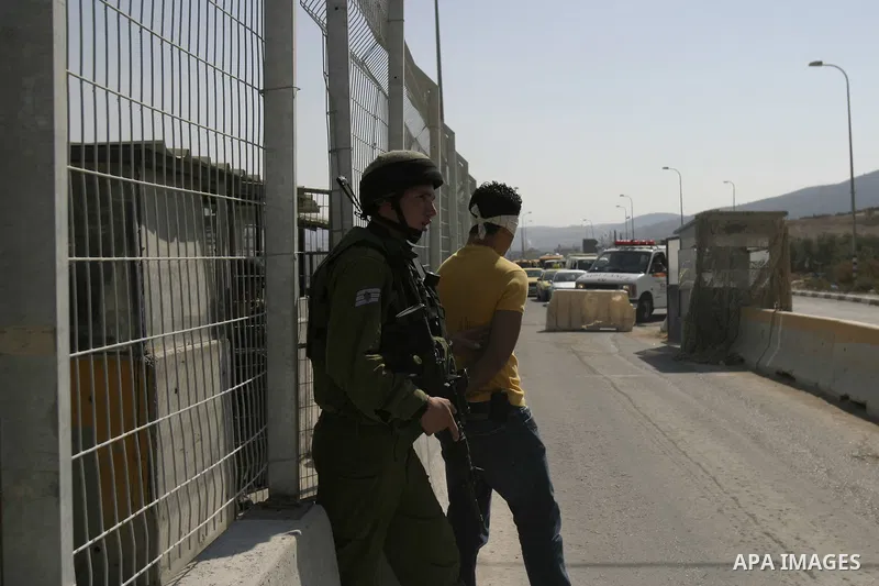 An Israeli soldier detains a Palestinian youth at the Hawara checkpoint near the West Bank city of Nablus. The Israeli military announced an open-ended closure of the West Bank and Gaza Strip Wednesday, ahead of the week...