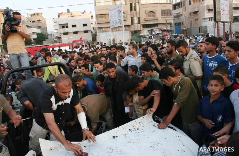 Palestinians gather around the wreckage of militants car after it was hit in an Israeli missile strike in the Zeitoun area in the east of Gaza City. Four Palestinian militants were killed in the strike.