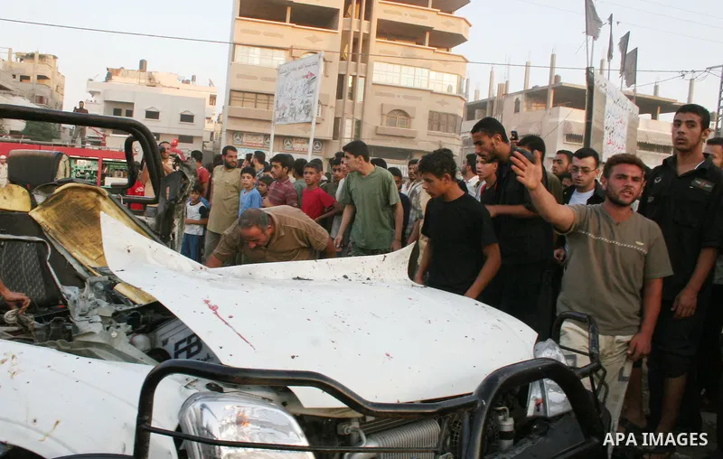 Palestinians gather around the wreckage of militants car after it was hit in an Israeli missile strike in the Zeitoun area in the east of Gaza City. Four Palestinian militants were killed in the strike.