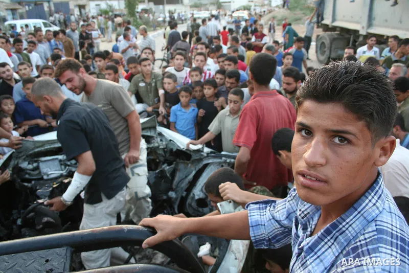 Palestinians gather around the wreckage of militants car after it was hit in an Israeli missile strike in the Zeitoun area in the east of Gaza City. Four Palestinian militants were killed in the strike.