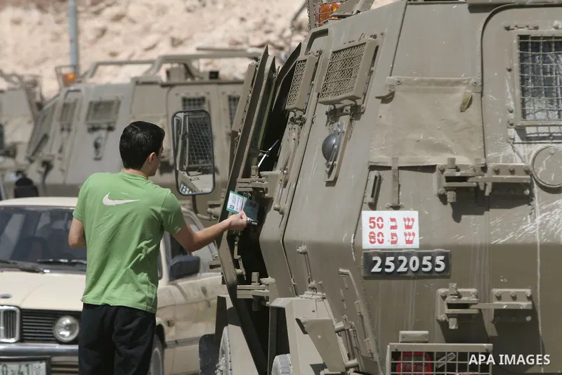Israeli troops check ID's Palestinian youth during raiding the West Bank town of Nablus. A Palestinian boy was wounded during the clashes, hospital sources said.