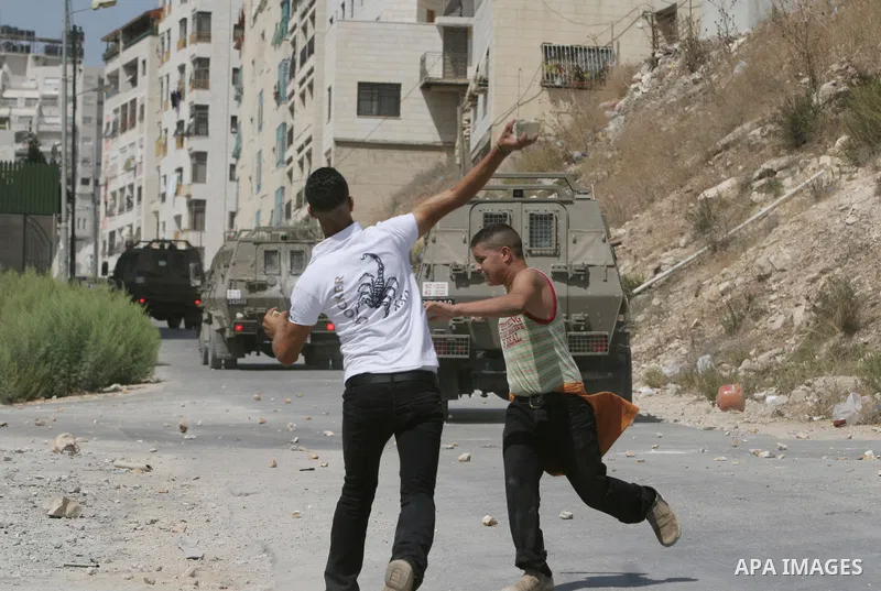 Palestinian youth hurling stones at Israeli troops raiding the West Bank town of Nablus. A Palestinian boy was wounded during the clashes, hospital sources said.