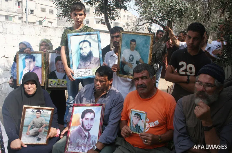 Palestinians hold pictures of incarcerated relatives as they attend a protest calling for the release of Palestinian prisoners held in Israeli jails, in Gaza. Israel began freeing dozens of Palestinian prisoners today af...