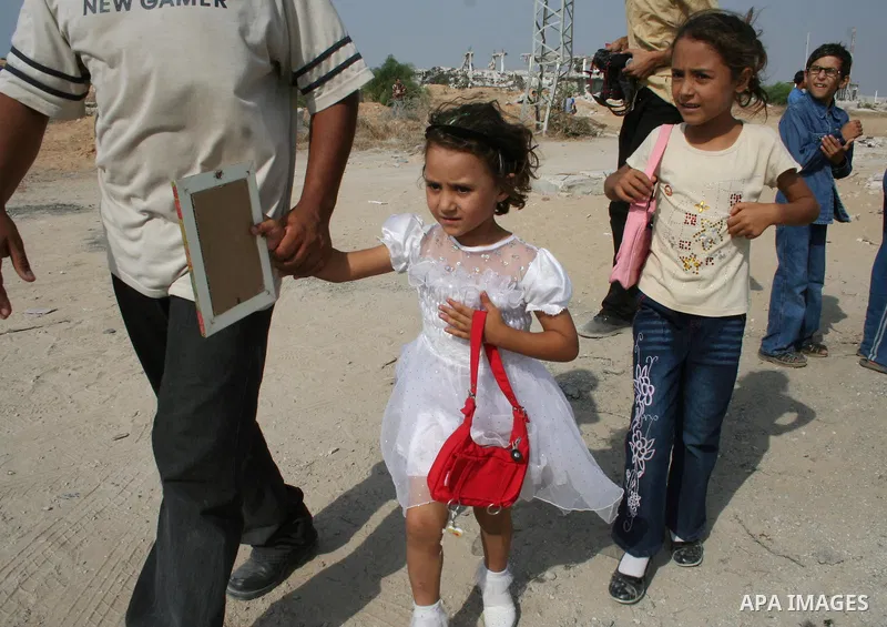 A Palestinian girls walk near the Erez border crossing between the Gaza Strip and Israel. Israel was expected to free 30 Palestinian prisoners in the Gaza Strip on Monday, but the release was delayed. Officials gave no e...