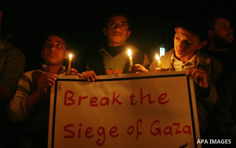 Palestinian youthes hold flames at a vigil demonstration in Gaza City against the Israeli blockade on the territory. Gaza's sole power plant shuddered to a halt after Israel refused to allow fuel into the besieged territ...