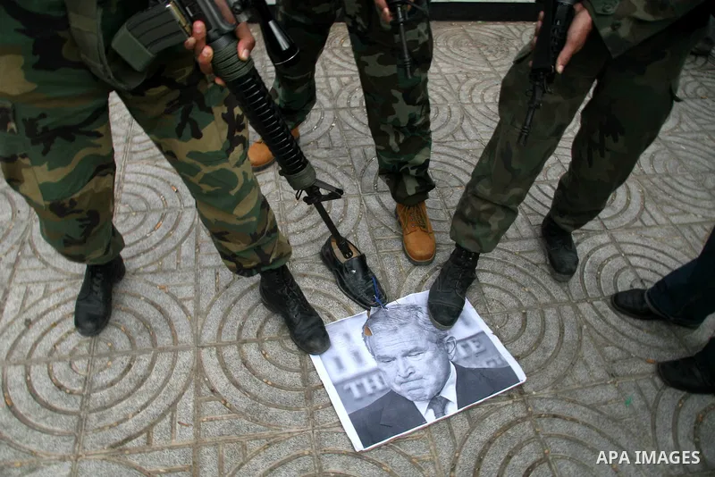 Palestinian militants burn a U.S and Israeli flag during a protest in Gaza. The protest, organised by popular resistant committees, was held in solidarity with Iraqi TV reporter Muntazer al-Zaidi, who threw his shoes at...