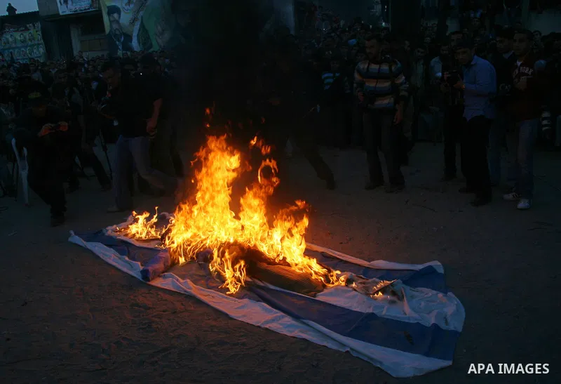 An effigy representing Israeli premier Ehud Olmert burn along with an Israeli flag during a rally by Palestinian militants of the Saraya Al-Quds (Jerusalem Brigades,) the military wing of the Islamic Jihad, in Gaza City....