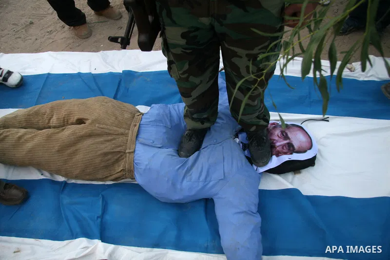 An effigy representing Israeli premier Ehud Olmert burn along with an Israeli flag during a rally by Palestinian militants of the Saraya Al-Quds (Jerusalem Brigades,) the military wing of the Islamic Jihad, in Gaza City....