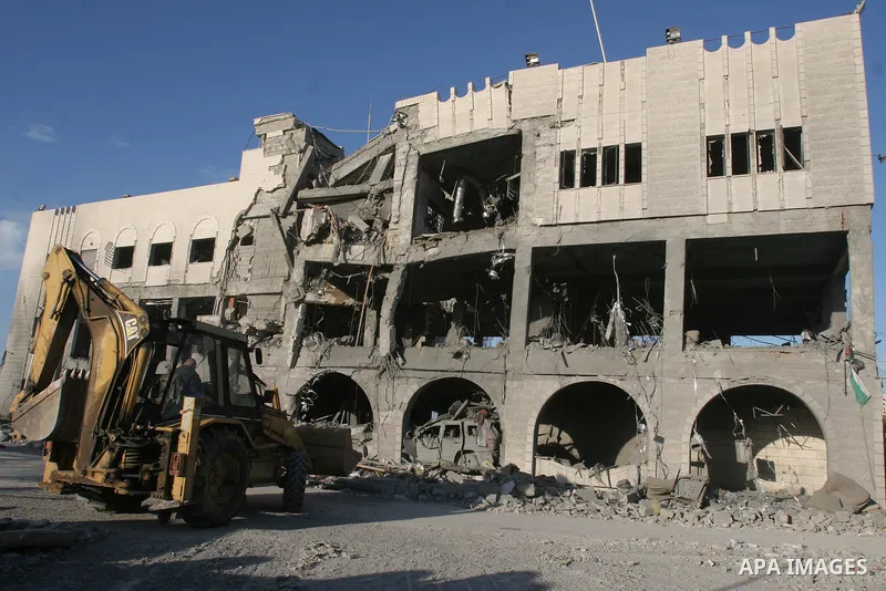 A member of the Hamas's security forces inspects a building that was destroyed by an Israeli air strike on Gaza City. Israel hammered Hamas targets in the Gaza Strip, killing at least 205 people in retaliation for ongoin...
