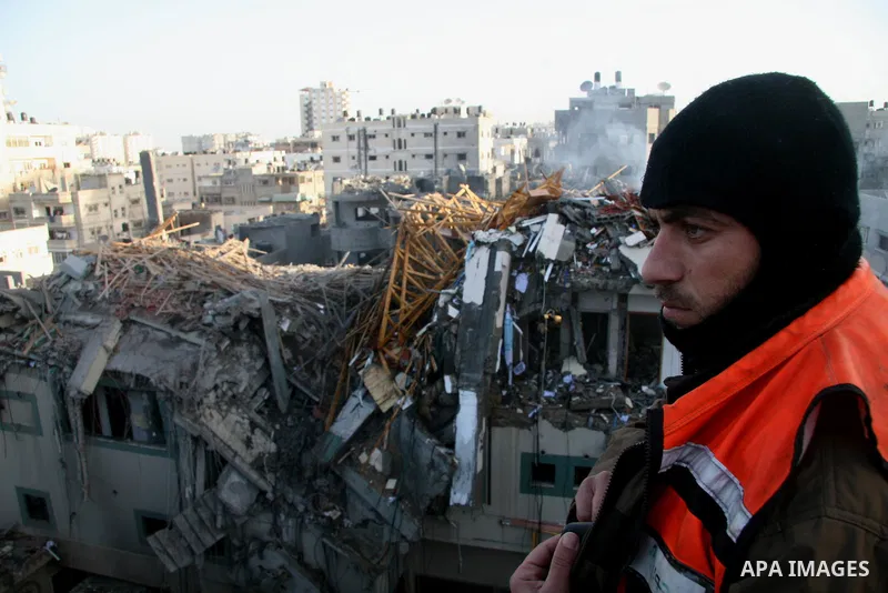 Palestinians look at destroyed buildings after an explosion from an Israeli missile strike in Gaza City. Israeli warplanes pounded the Hamas-ruled Gaza Strip for a third consecutive day on Monday and the Jewish state pre...