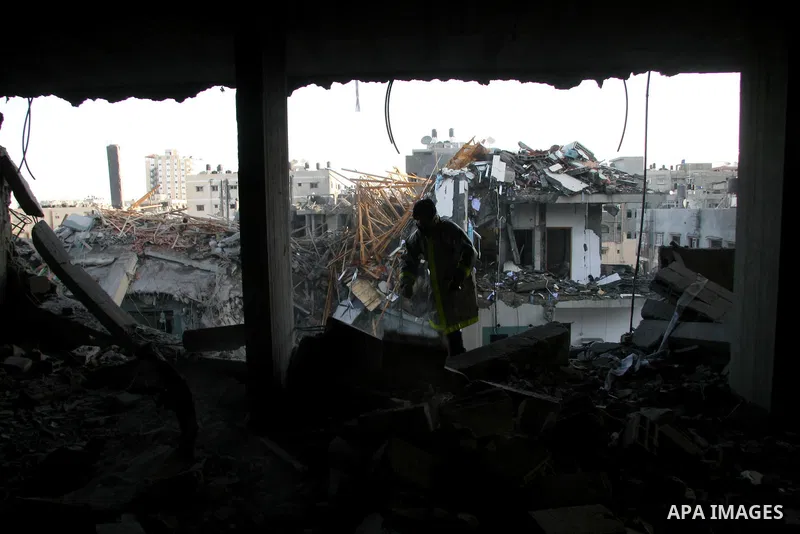 Palestinians look at destroyed buildings after an explosion from an Israeli missile strike in Gaza City. Israeli warplanes pounded the Hamas-ruled Gaza Strip for a third consecutive day on Monday and the Jewish state pre...