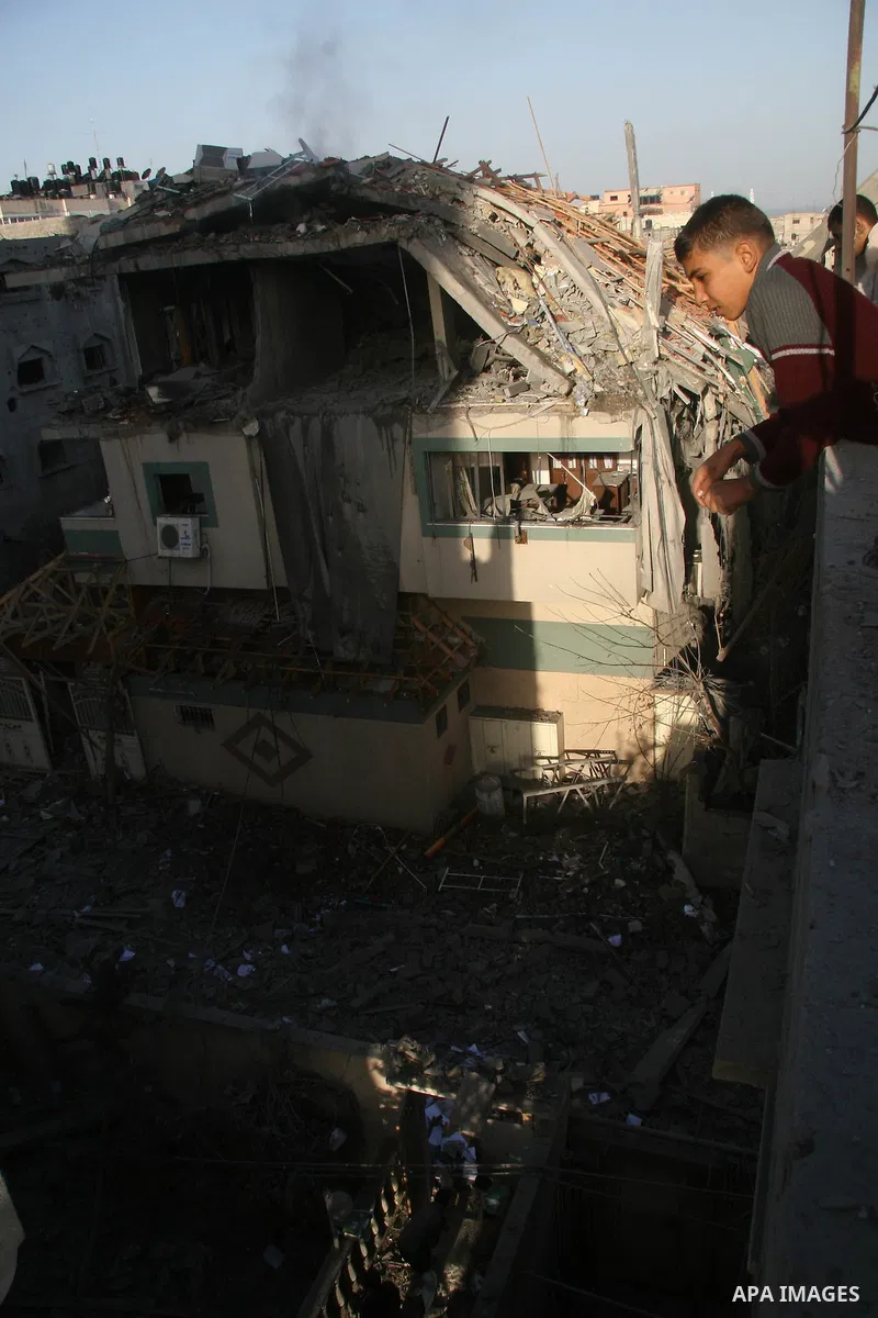 Palestinians look at destroyed buildings after an explosion from an Israeli missile strike in Gaza City. Israeli warplanes pounded the Hamas-ruled Gaza Strip for a third consecutive day on Monday and the Jewish state pre...