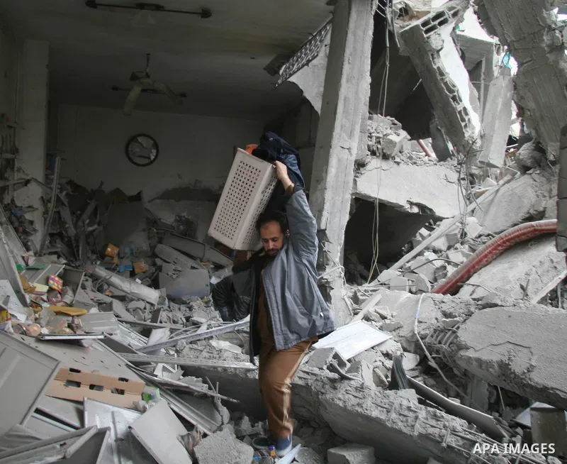 Palestinians look at destroyed buildings after an explosion from an Israeli missile strike in Gaza City. Israeli warplanes pounded the Hamas-ruled Gaza Strip for a third consecutive day on Monday and the Jewish state pre...