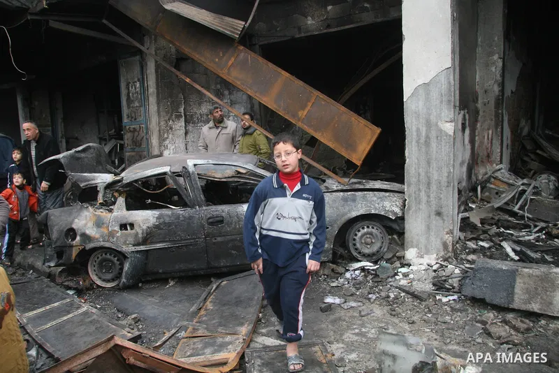 Palestinians look at destroyed buildings after an explosion from an Israeli missile strike in Gaza City. Israeli warplanes pounded the Hamas-ruled Gaza Strip for a third consecutive day on Monday and the Jewish state pre...
