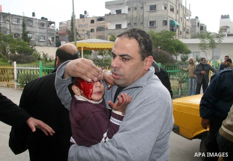 A Palestinian man carries his wounded child to the treatment room of Kamal Edwan hospital following an Israeli missile strike in Beit Lahiya, northern Gaza Strip, Monday, Dec. 29, 2008. Israel's overwhelming air campaign...