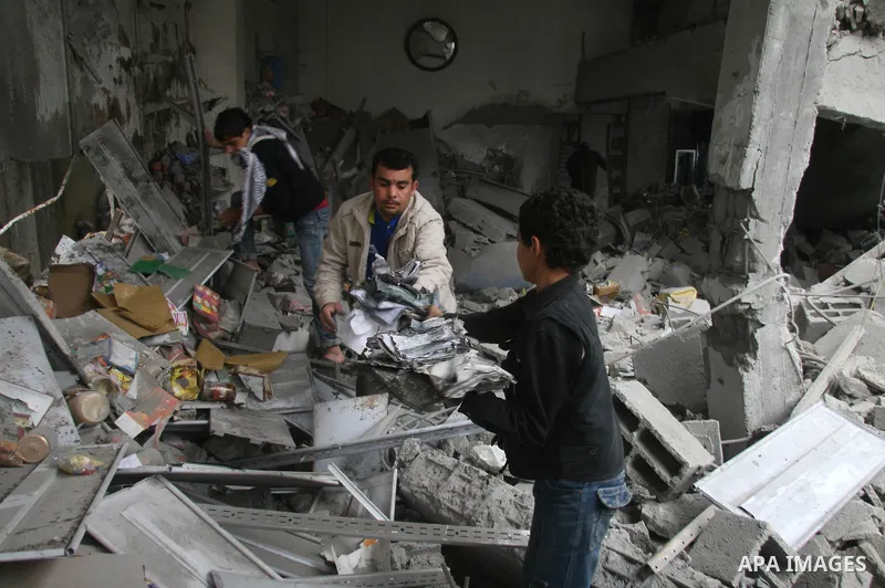 Palestinians look at destroyed buildings after an explosion from an Israeli missile strike in Gaza City. Israeli warplanes pounded the Hamas-ruled Gaza Strip for a third consecutive day on Monday and the Jewish state pre...