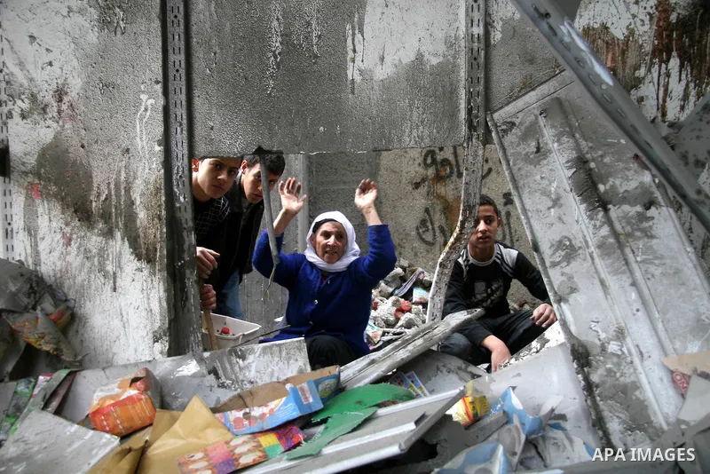Palestinians look at destroyed buildings after an explosion from an Israeli missile strike in Gaza City. Israeli warplanes pounded the Hamas-ruled Gaza Strip for a third consecutive day on Monday and the Jewish state pre...