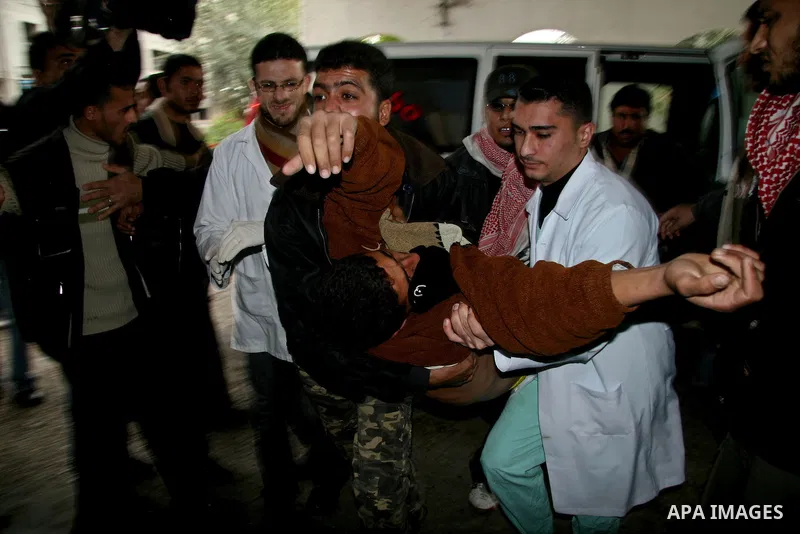 Palestinians carry a wounded man, following an Israeli missile strike, into the Shifa hospital in Gaza City, Tuesday, Dec. 30, 2008. Early Tuesday, Israeli aircraft dropped at least 16 bombs on five Hamas government buil...