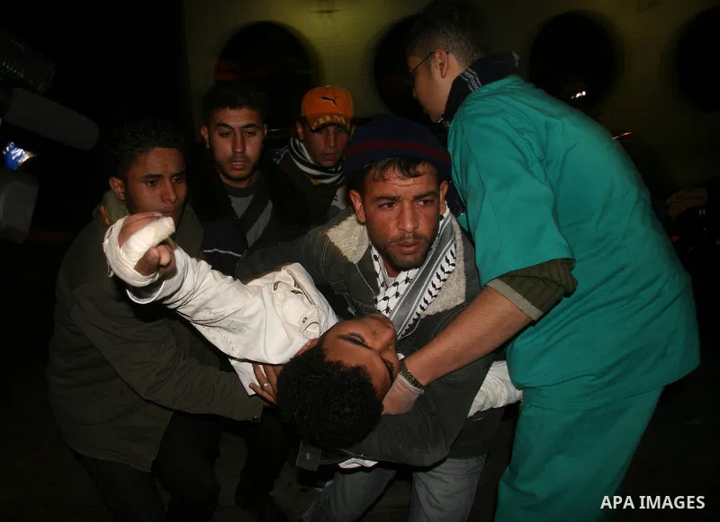 Palestinians carry a wounded man, following an Israeli missile strike, into the Shifa hospital in Gaza City, Tuesday, Dec. 30, 2008. Early Tuesday, Israeli aircraft dropped at least 16 bombs on five Hamas government buil...