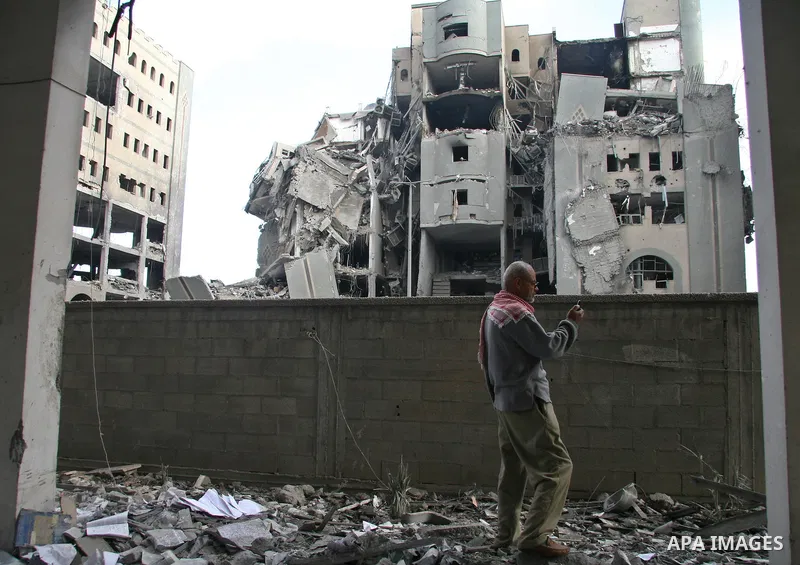 A Palestinian man walks past destroyed Hamas government buildings after an Israeli air strike in Gaza December 30, 2008. Israeli warplanes killed 10 Palestinians on Tuesday in attacks that targeted Hamas government build...