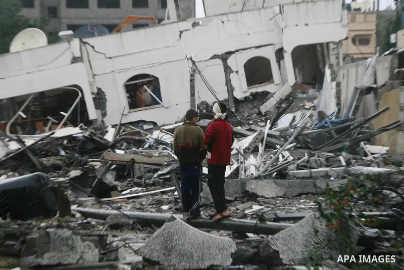 Palestinians inspect the destoryed offices of the head of the Hamas government in Gaza following overnight Israeli airstrikes on Gaza City. Hamas vowed on Wednesday to fight "until the last breath" if Israel makes good o...