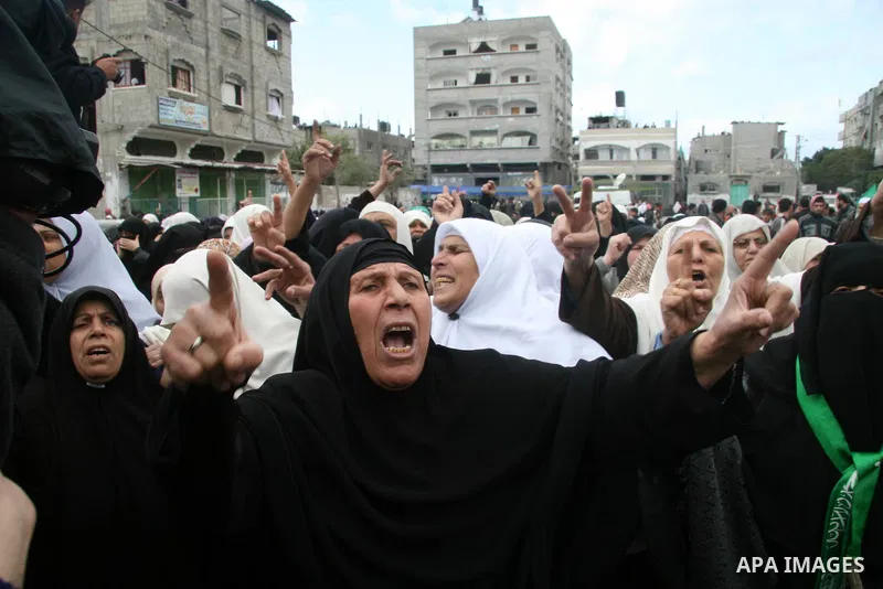 Palestinian women chant slogans during the funeral of Hamas leader Nizar Rayan, and four of his wives and ten of his children, who were killed Thursday in an Israeli airstrike, in the town of Beit Lahiya, northern Gaza S...