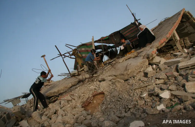 A Palestinian family works on the rubble of their home destroyed during Israel's 22-day offensive in Jabalia in the northern Gaza Strip on February 16, 2009. Israeli aircraft struck smuggling tunnels on Gaza's border wit...
