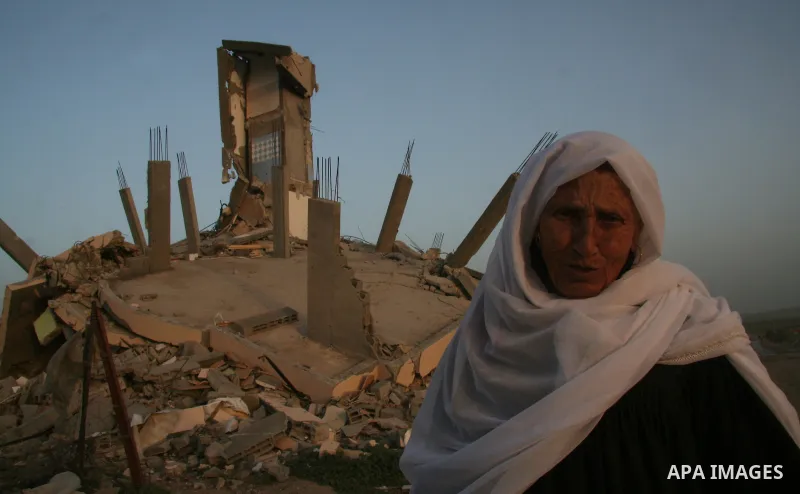 A Palestinian woman walks past a house destroyed during Israel's 22-day offensive in Jabalia in the northern Gaza Strip on February 16, 2009. Israeli aircraft struck smuggling tunnels on Gaza's border with Egypt, after t...