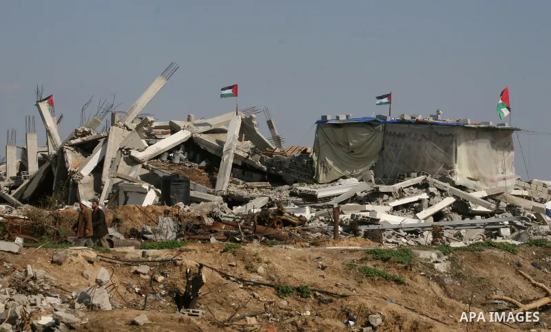 A Palestinian family sit on the rubble of their home destroyed during Israel's 22-day offensive in Jabalia in the northern Gaza Strip on February 18, 2009 APAIMAGES PHOTO / Ashraf Amra